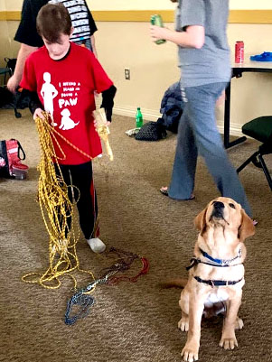 Izaac Reese gathers a section of rope at Saturday’s class while another student settles into the little-known upward-facing dog pose. Photo by Vivian Drury