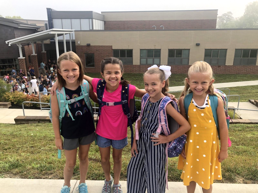 Students Ezra Pechan-Keeton, Brooklyn Porchowsky, Ellie Porchowsky, and Mira Pechan-Keeton pose for pictures in front of Kramer Elementary on the first day of school Wednesday. Photo by Halie Barger
