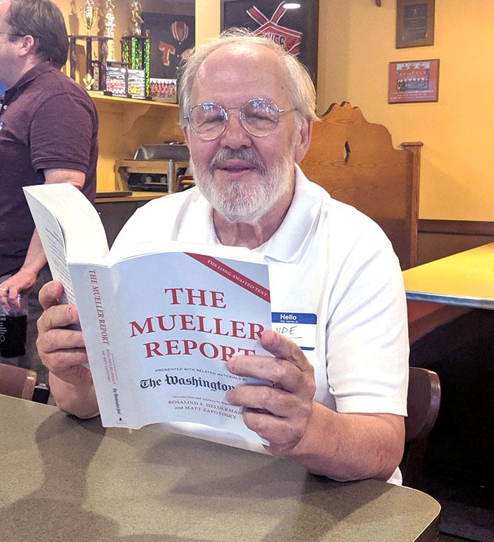 Clyde Brown, reading the report on the Mueller Investigation of the Trump administration while attending a Democratic Debate watching party in Oxford last June. <em>Observer file photo</em>
