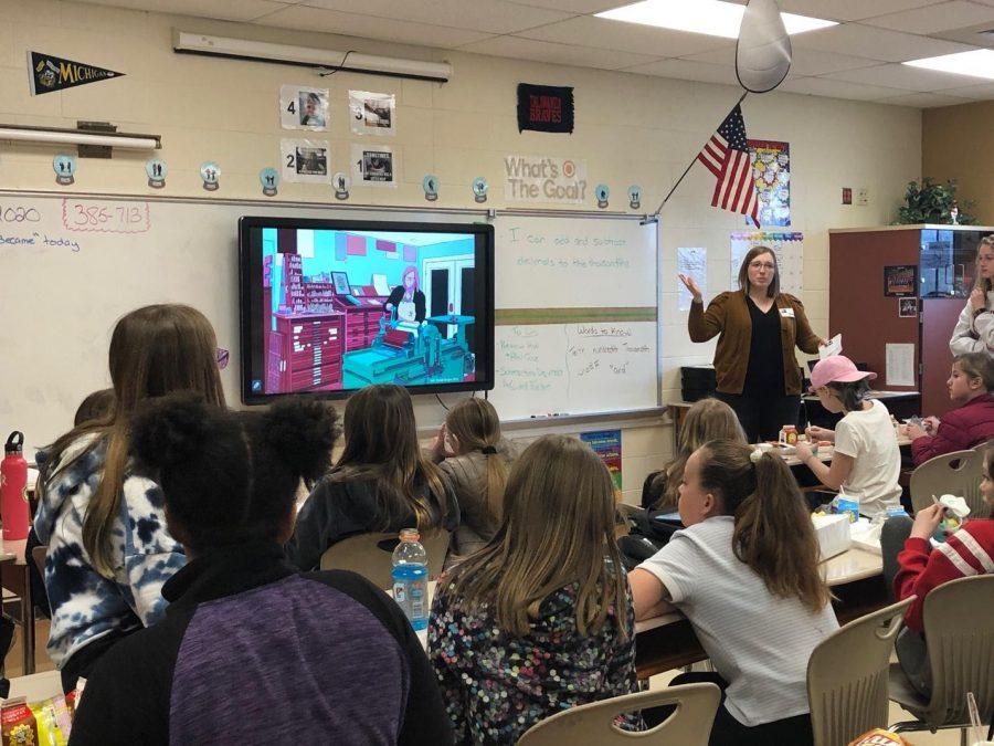Miami professor Erin Beckloff, graphic designer and movie director, presents a piece of art about letterpress printing to the “She Became” group during a lunch program at Bogan Elementary School. Photo by Emma Kinghorn
