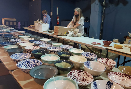 Volunteers set up handmade bowls for the Empty Bowls online sale.