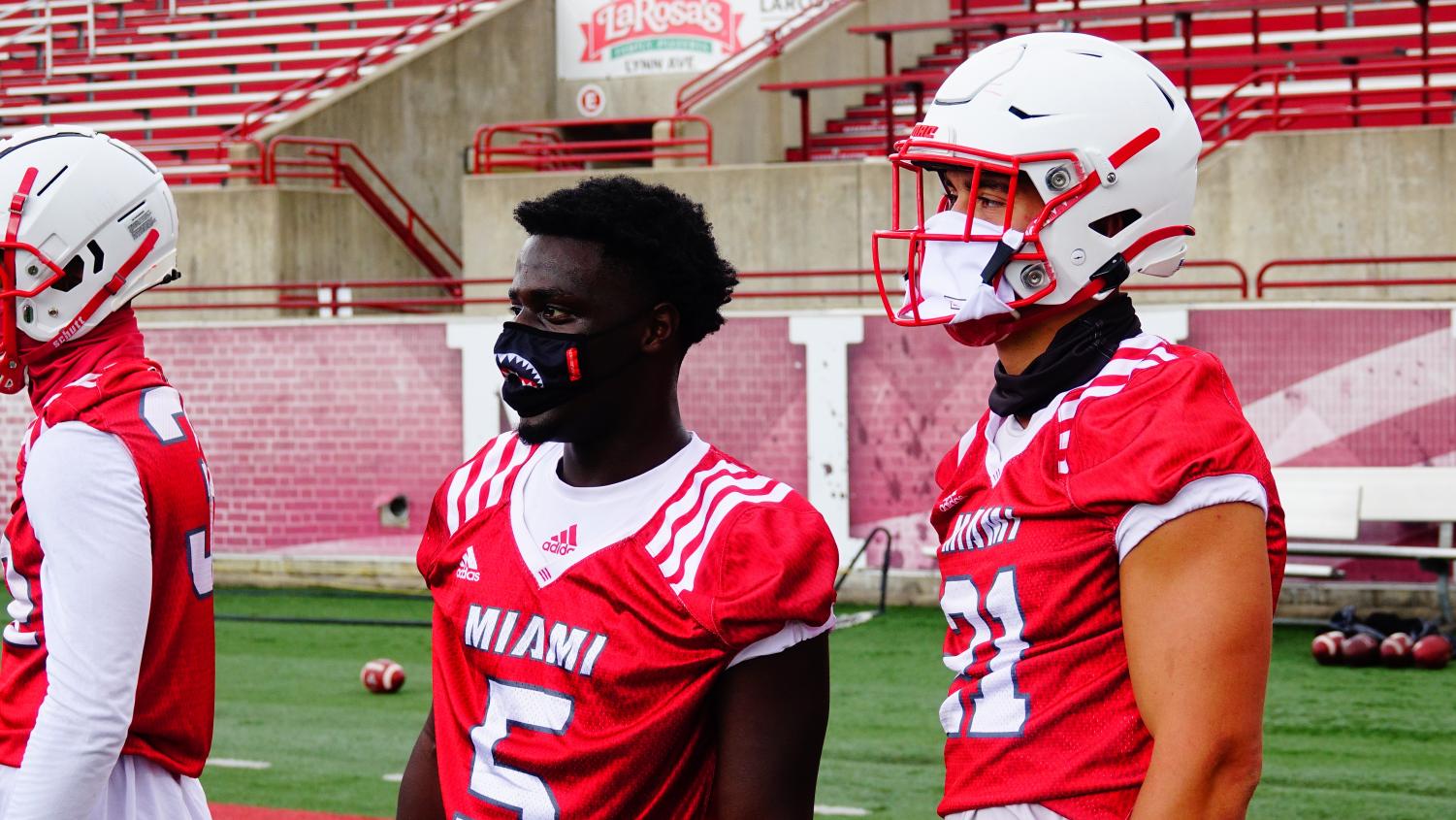 Miami football players wear masks on and off the field to mitigate the spread of COVID-19 