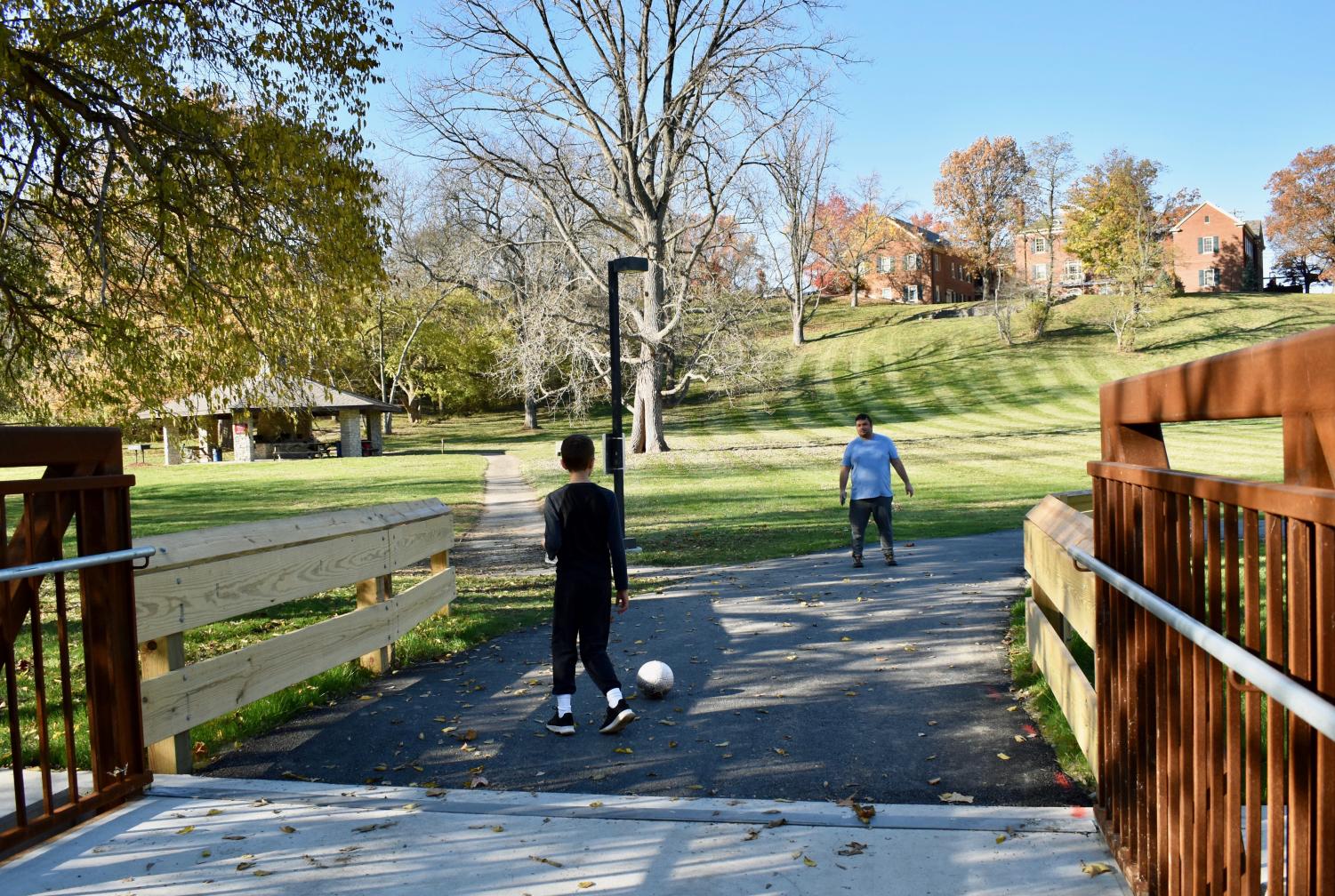 Jared Coffin (right) kicks a ball around with younger brother Isaac at the Peffer Park bridge, the site depicted in his mural.