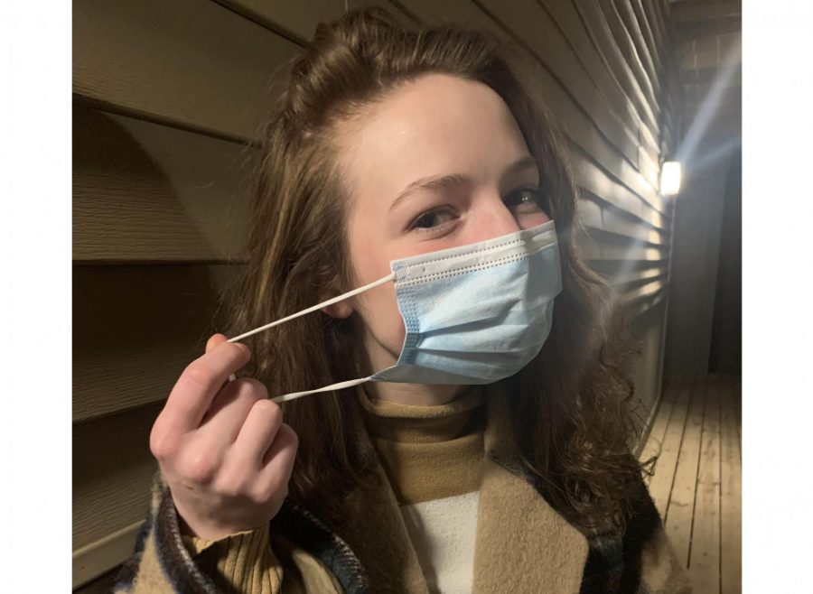 Miami student Allie Brown demonstrates the double masking now being recommended as a precaution against new, more transmissible variants of COVID-19. Step #1: Brown puts on a standard paper medical-style mask.