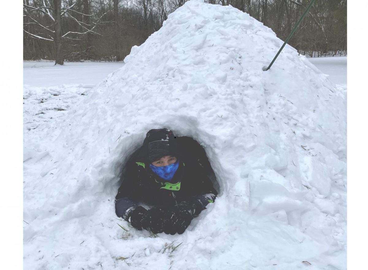 Oxford resident Isaac Coffin peeks out the door of the quinzee Canadian snow shelter, built by the staff of Miami’s Outdoor Pursuit Center, Wednesday afternoon in Peffer Park. The event was part of Miami’s Wellness Day program. 