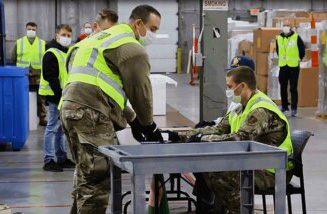 Ohio Gov. Mike DeWine says the widening availability of COVID-19 vaccines is helping end the pandemic. Here, members of the Ohio National Guard in Columbus pack up doses of vaccine for distribution around the state.