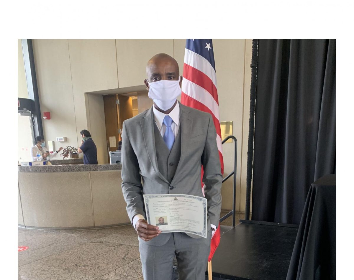 Godwin Agaba holds his naturalization certificate the day he took his oath of citizenship on Feb. 8, at Sinclair Community College in Dayton.