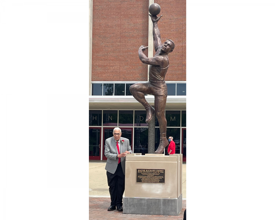 Embry poses beside the statue of himself in front of Millett Hall. 