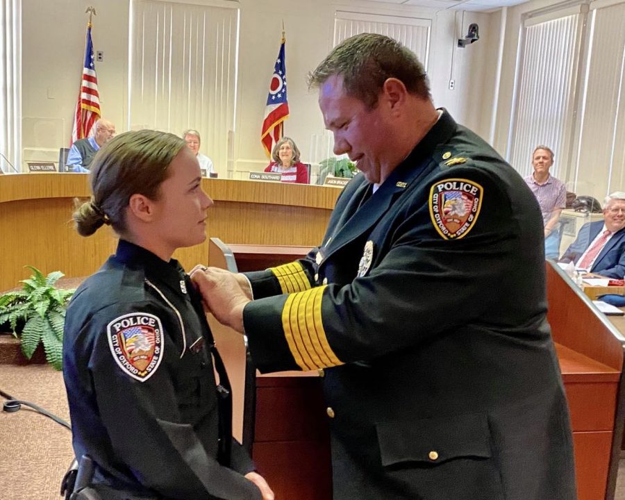 Oxford Police Chief John Jones pins the badge on Brooke Hartwig, newest officer on the city police force, at the June 15 meeting of city council.