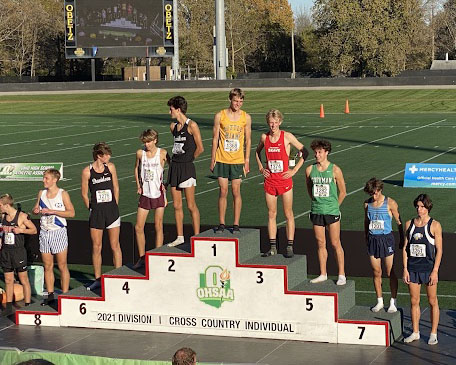 Kiefer Bell (in red) in the #3 spot on the winner’s platform at last week’s state cross country championships