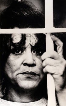 A victim of domestic violence peering through bars is one of the Donna Ferrato photographs on display at the Miami University Art Museum. 