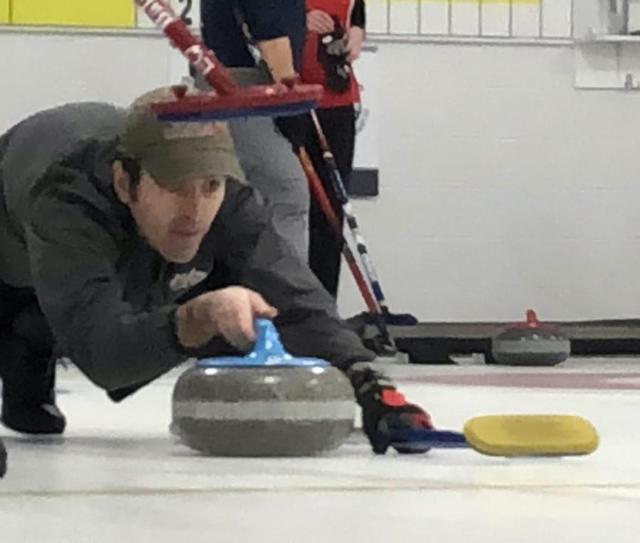 A player at the Cincinnati Curling Club takes careful  aim before sliding his stone down the ice. 