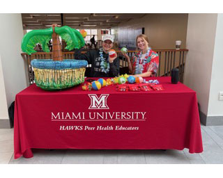 Miami HAWKS members Lora Ontl (left) and Amanda Nelson work the organization’s table at Armstrong Student Center during the week before Spring Break. They were handing out free mini wallets with information on how to have a safe spring break, along with items like sunscreen and contraceptives. 