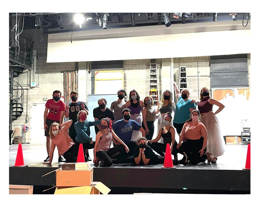 The cast of “Head over Heels” gathers on stage after a recent rehearsal. Performers must still wear masks during rehearsals on campus. 