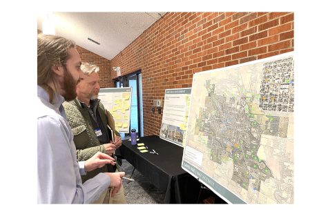 Evan Pitts (front) and Robert Bell (back) discuss employment opportunities they want to see in the future in Oxford. They placed colored dots on the city map to show where they would like these employment centers to be. 