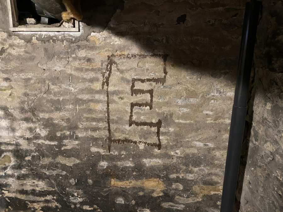 This mysterious E appears on the wall of the basement with no explanation. The current residents don’t know what causes it. 