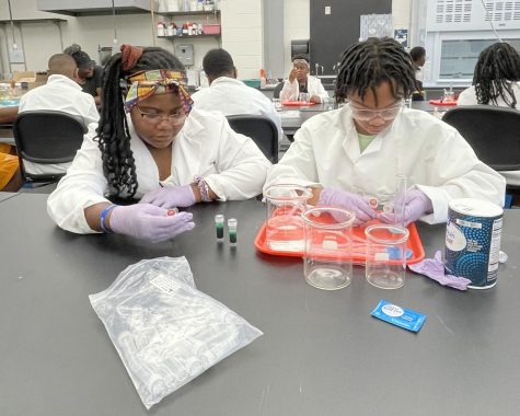Visiting Cincinnati Public Schools students conduct an experiment with Alka Seltzer and salt. 
