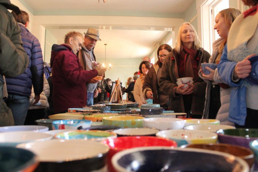 Guests+pick+out+bowls+to+fill+with+lunch+at+the+Oxford+Empty+Bowls+project+in+2018.