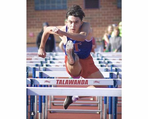 Julio Fuentes sprints to a school record 14.88 second finish in the 110-meter hurdles at the SWOC championship meet. 