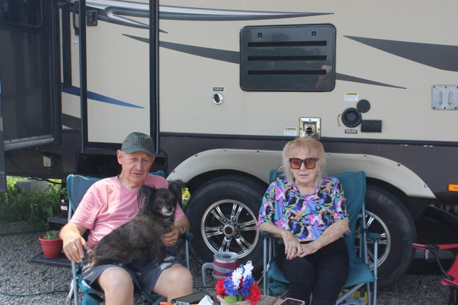 Robert and Patricia Hoffman sit in front of their temporary camper home, yards away from the skeleton of their old home. 