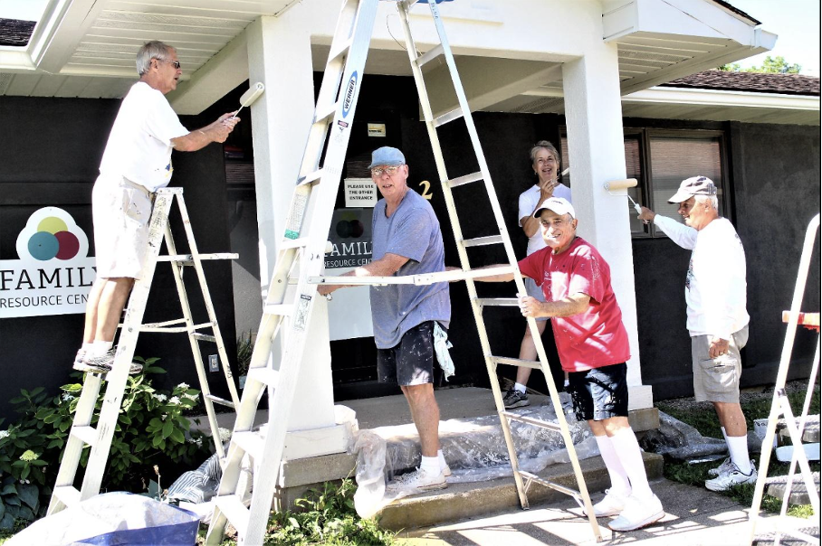 Kiwanis members Dave Belka, John Skillings, John Gieranger, Jim Kehr and Jim Forry work together to paint the front of the TOPSS building. 