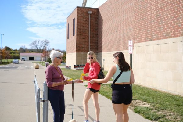 A political activist hands out flyers to voters on Election Day 2023 outside  Talawanda High School.