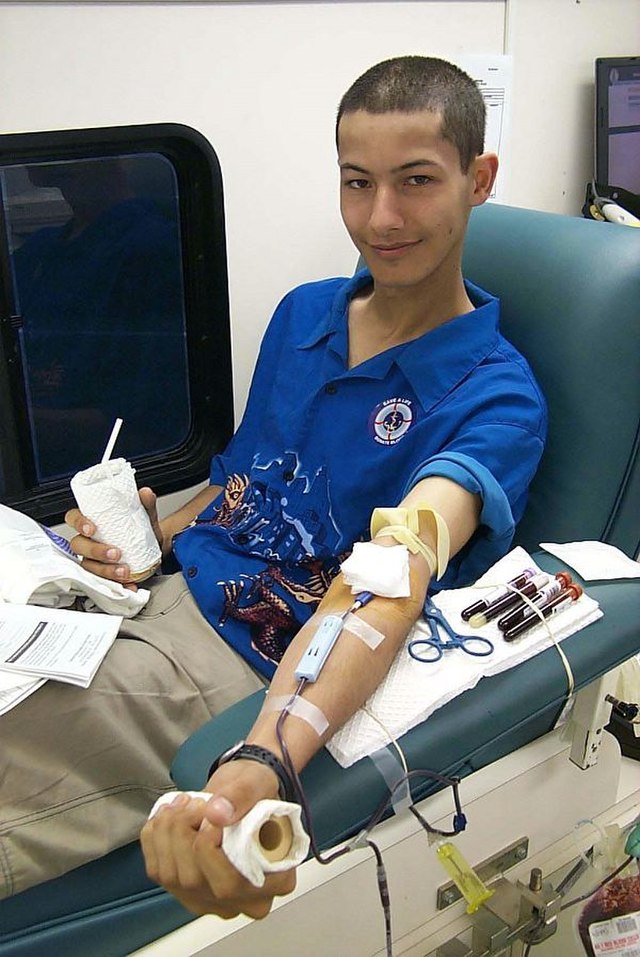 US-Navy Storekeeper 3rd Class Robert Franke donates blood. Photographer is Mate 3rd Class Michael Buslovich.