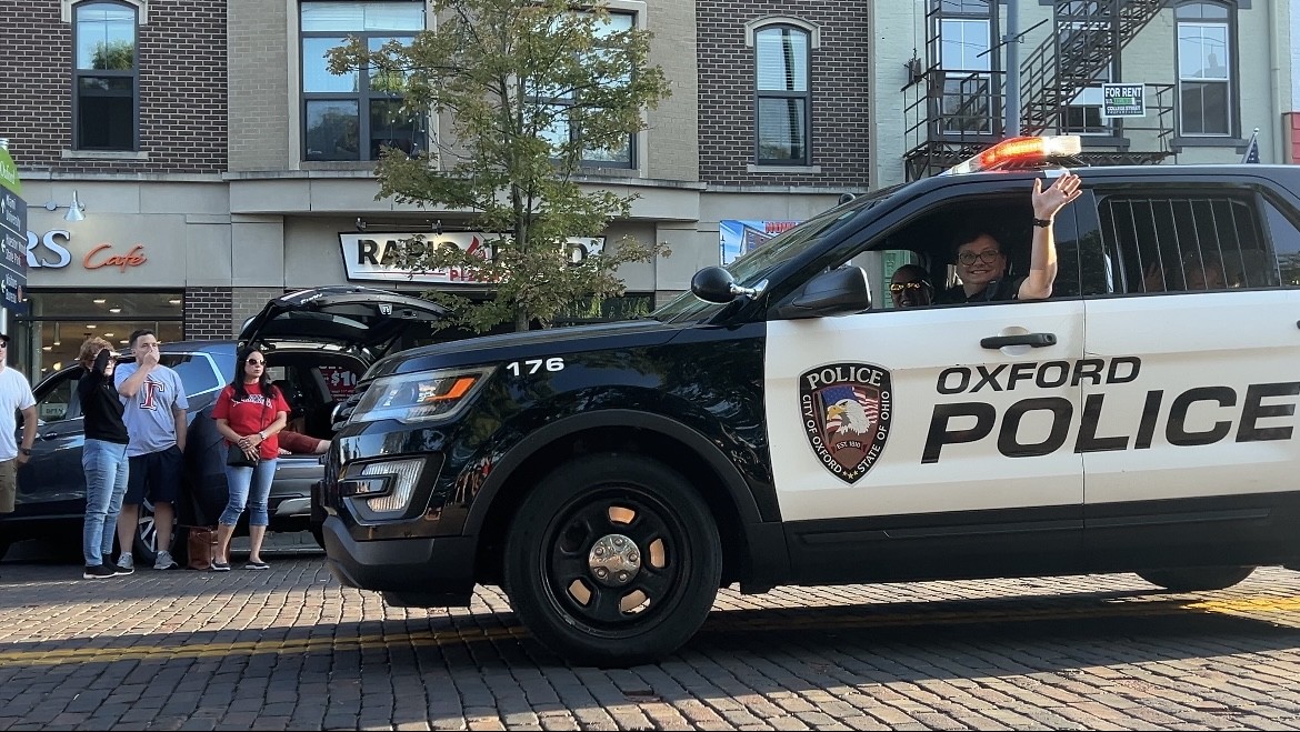 Oxford Police Sergeant Shelly Sikora smiles at Oxford locals seated alongside High Street for the Talawanda Homecoming parade Sept. 19. 