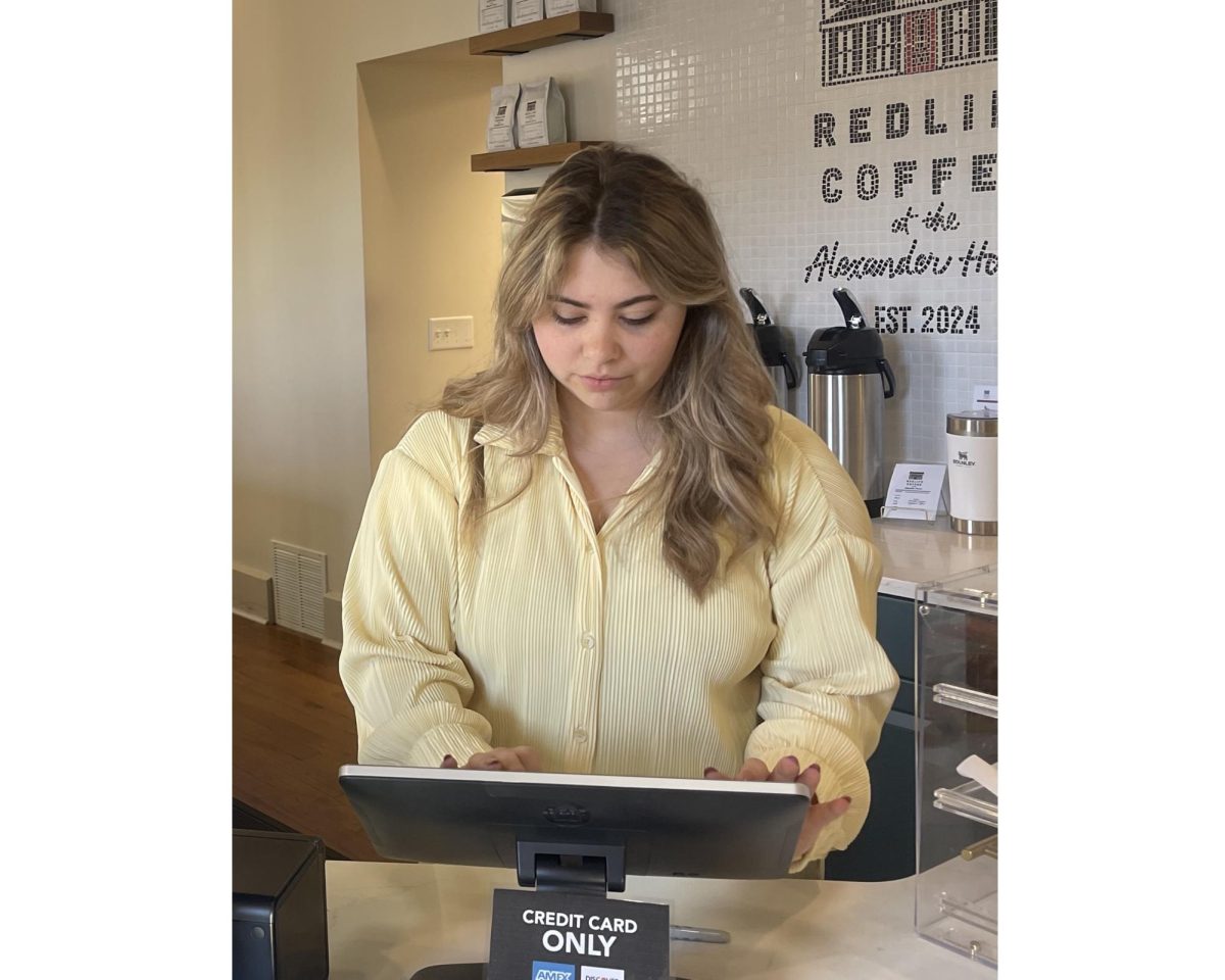 Sara Rose Detwiler, employee of the RedLife Coffee shop, takes orders at the register. 