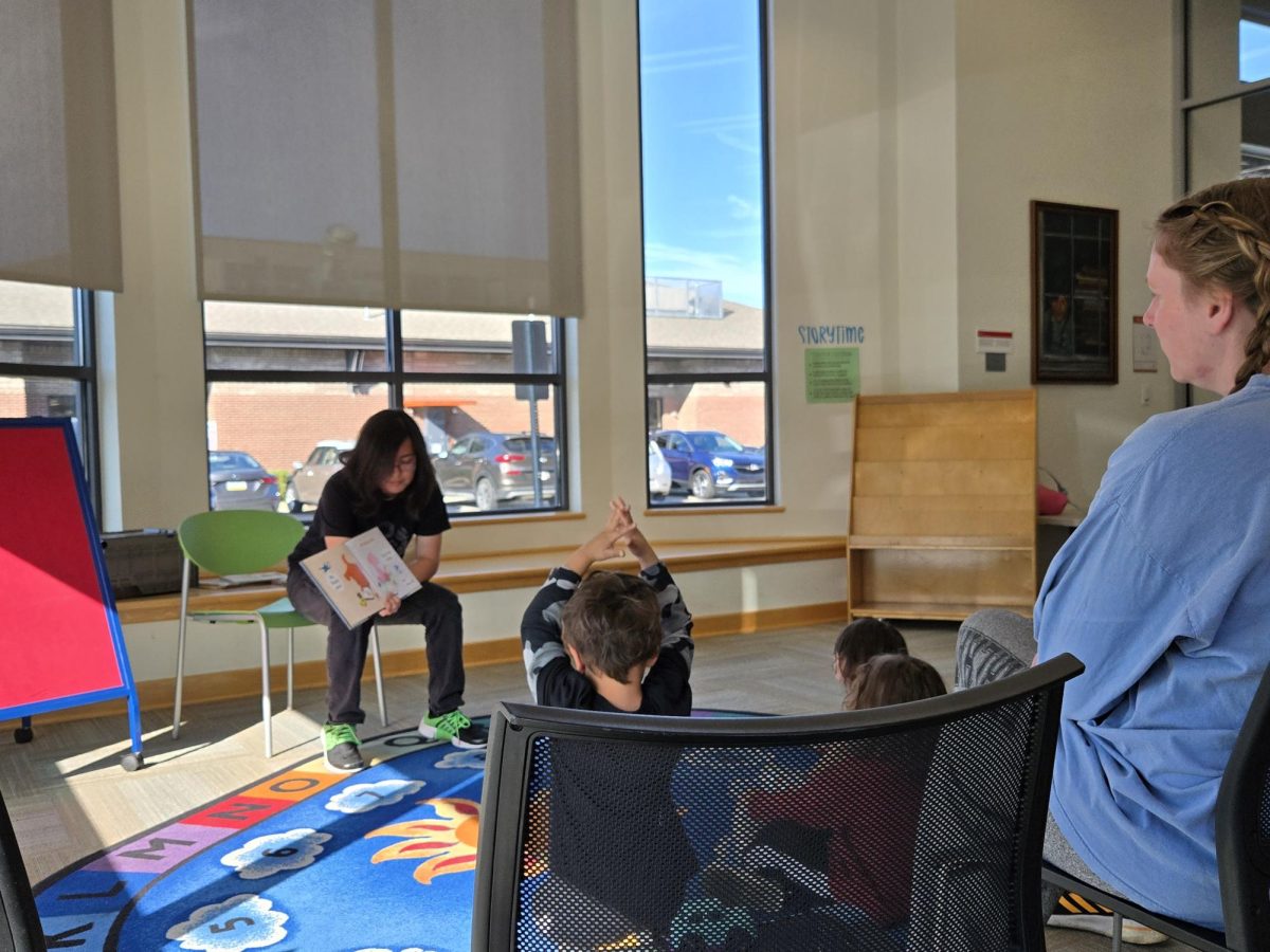 Oxford Lane Library employee Fabio Chirinos reads to children at the library. 