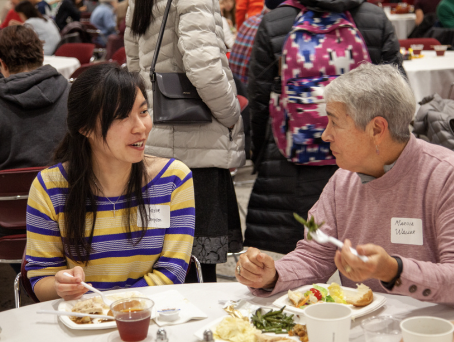 Student and community member enjoy a Thanksgiving dinner.