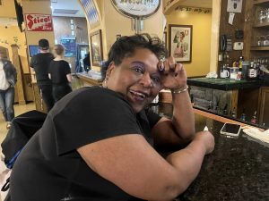 Gina Stigall poses in the midst of a shift but still gives a big smile.