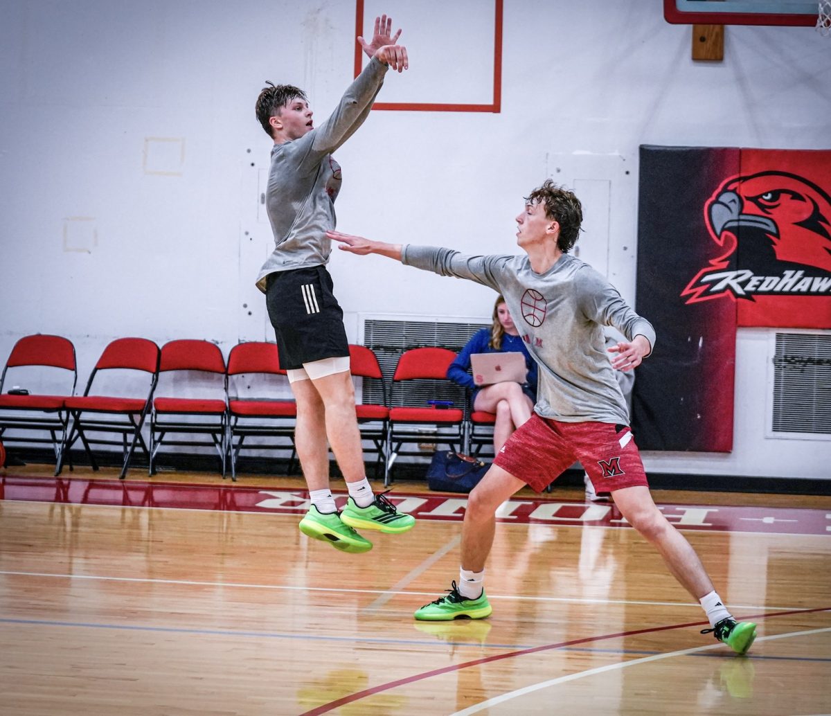 Evan Ipsaro elevates for a jumper over Brant Byers. 
